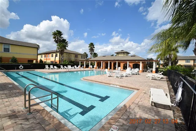 a view of a house with swimming pool and sitting area