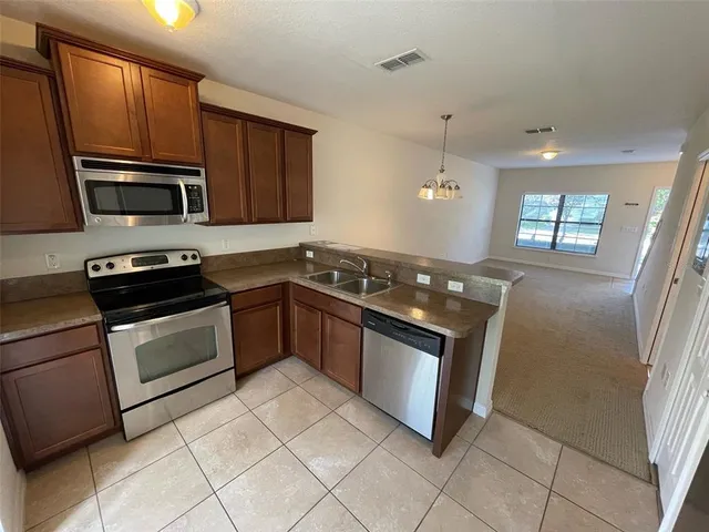 a kitchen with stainless steel appliances granite countertop a stove a microwave and a sink