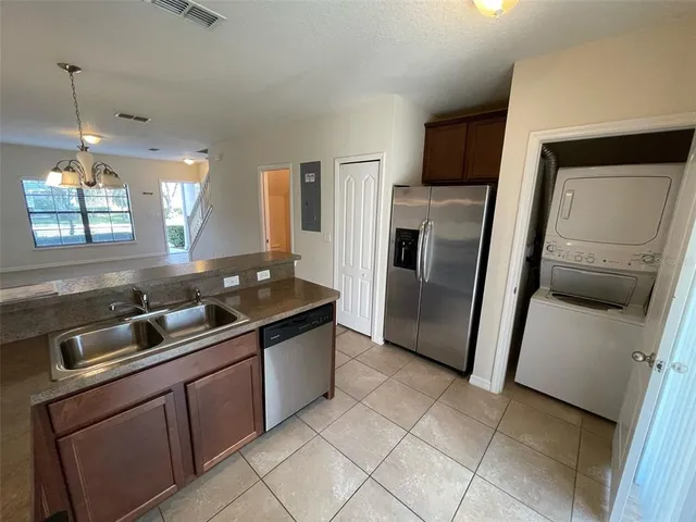 a kitchen with granite countertop a refrigerator and a sink