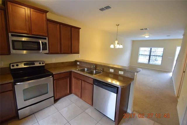 a kitchen with granite countertop stainless steel appliances and wooden cabinets