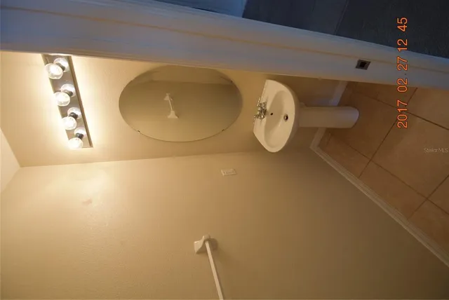 a picture of a bathroom with a sink and mirror