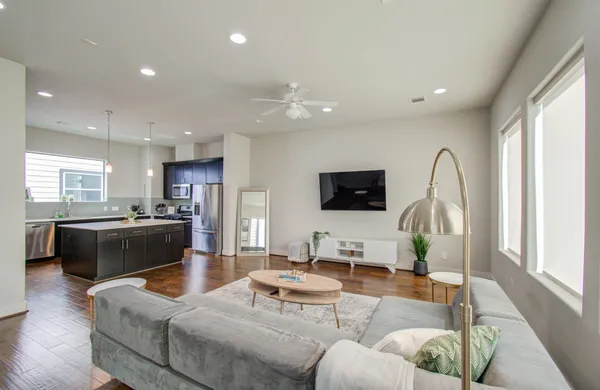 a living room with furniture kitchen view and a flat screen tv