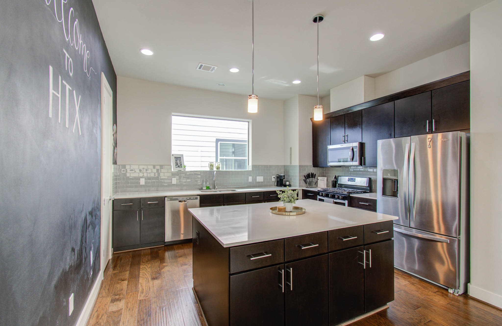 509 Gregg Street Houston, TX 77020 - Photo 22 of 38 a kitchen with a sink a kitchen island a stove a refrigerator cabinets and a dining table