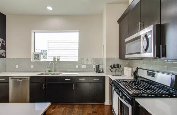 a kitchen with stainless steel appliances a sink stove and cabinets