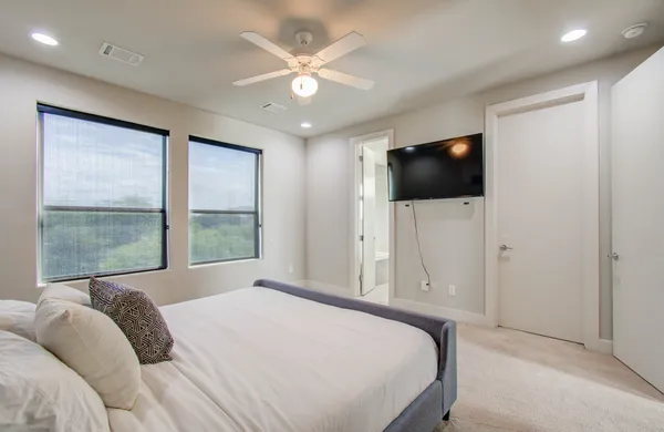 a bedroom with a large bed and a flat screen tv