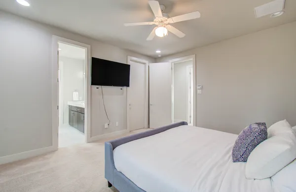 a bedroom with a large bed and a flat tv screen on a dresser