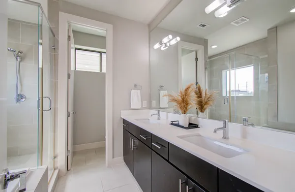 a bathroom with a double vanity sink mirror and shower