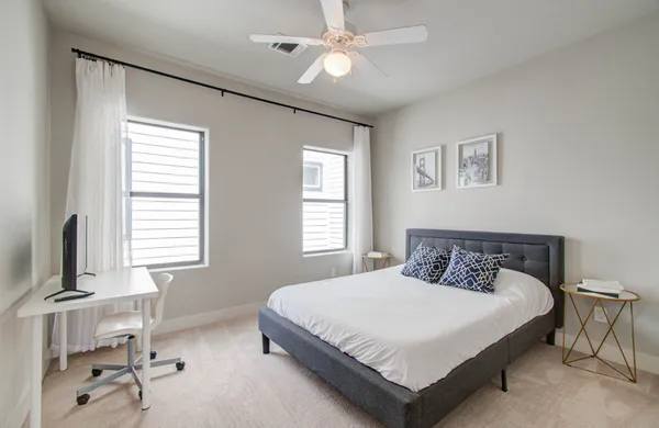 a bedroom with a bed and a table in it with window