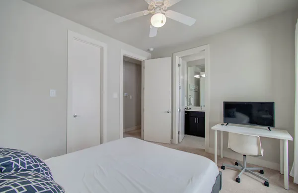 a bedroom with a bed and a flat tv screen on the dresser