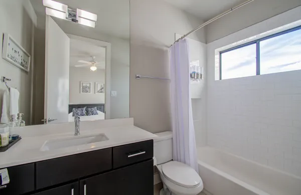 a bathroom with a sink a toilet a mirror and shower