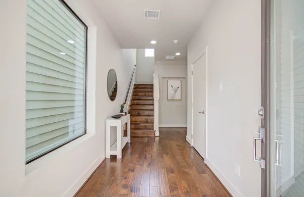 a view of a hallway with wooden floor and staircase