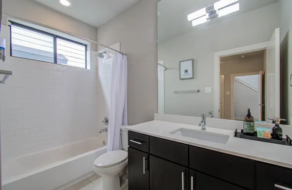 a bathroom with a double vanity sink toilet mirror and bathtub