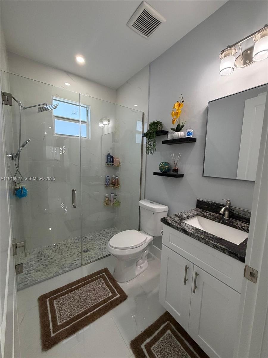 2923 22nd Street Southwest Lehigh Acres, FL 33976 - Photo 12 of 24 a bathroom with a sink a toilet and shower