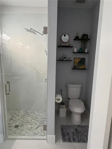 a bathroom with a toilet and a shower