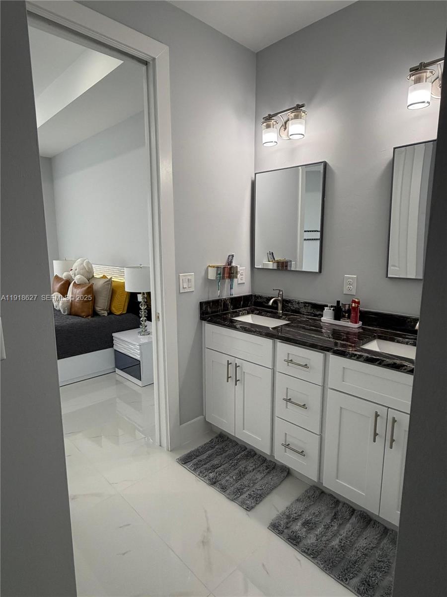 2923 22nd Street Southwest Lehigh Acres, FL 33976 - Photo 14 of 24 a spacious bathroom with a double vanity sink and a mirror
