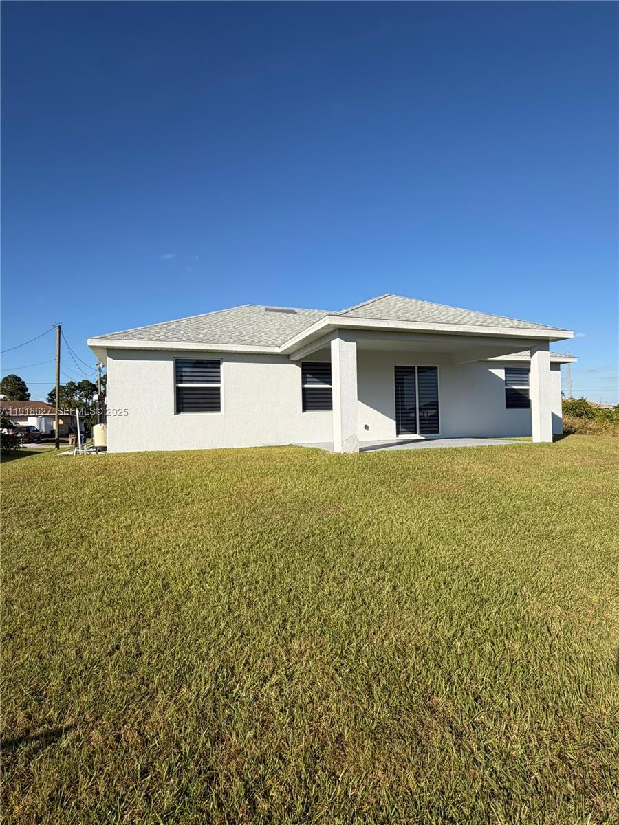 2923 22nd Street Southwest Lehigh Acres, FL 33976 - Photo 23 of 24 a view of a house with a yard