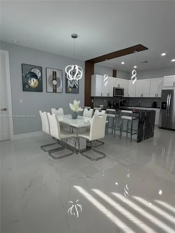 a living room with lots of furniture and kitchen view