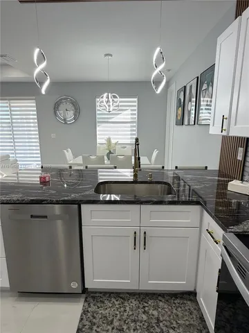 a kitchen with granite countertop a sink and cabinets