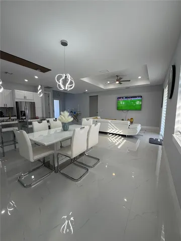 a living room with dining room and couches with kitchen view