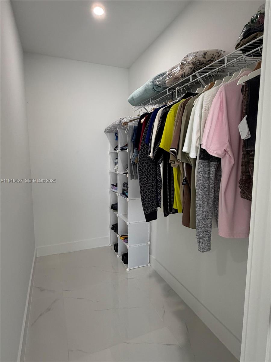 2923 22nd Street Southwest Lehigh Acres, FL 33976 - Photo 10 of 24 a view of walk in closet with clothes and shoes