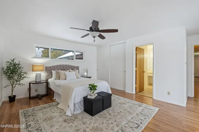 a view of an empty room with wooden floor and stairs