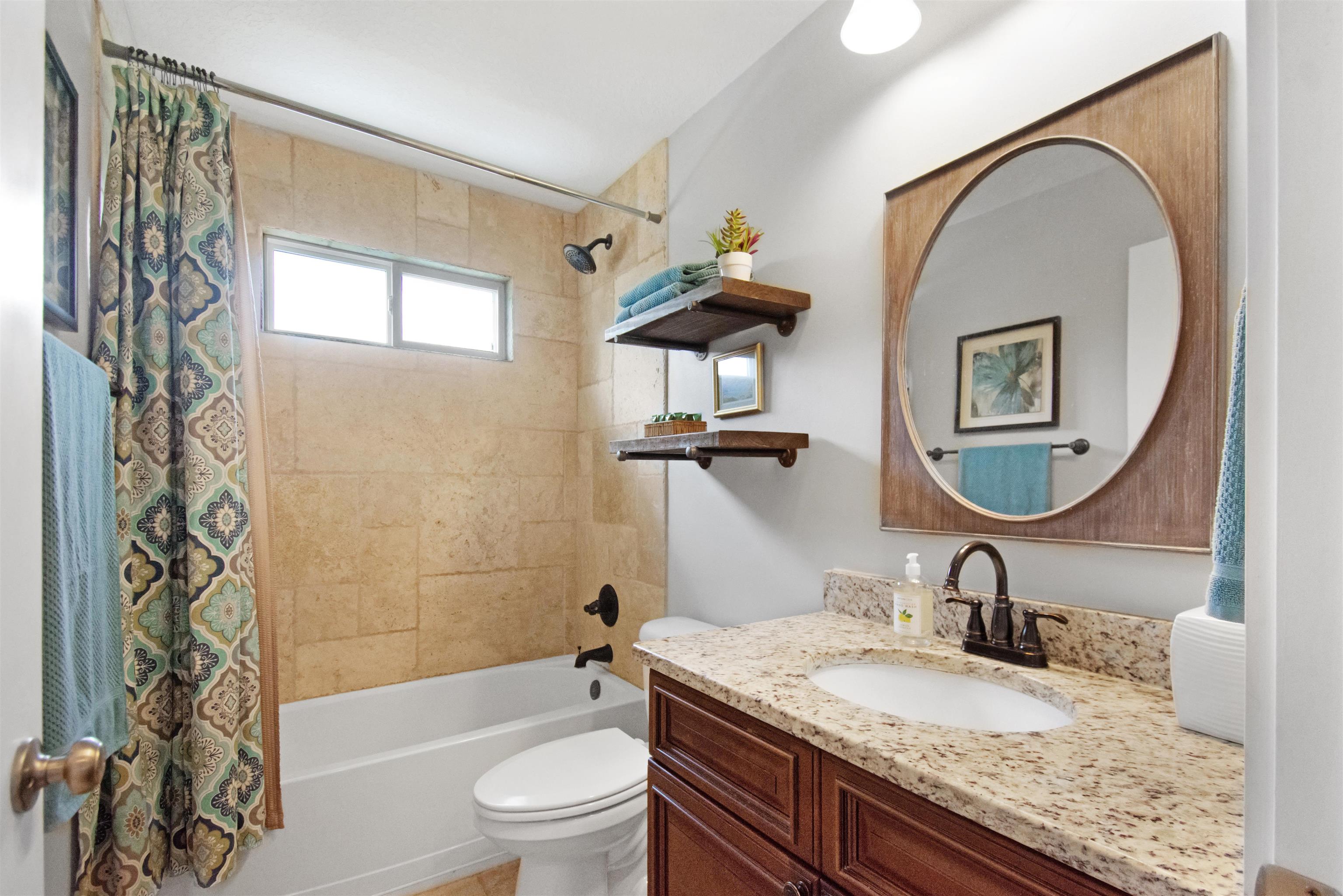 13 Court Edna St. Augustine, FL 32084 - Photo 27 of 59 a bathroom with a granite countertop toilet a sink and a mirror