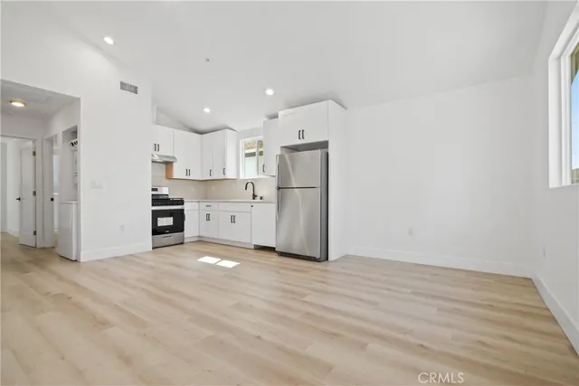 a view of a kitchen with a sink and a refrigerator