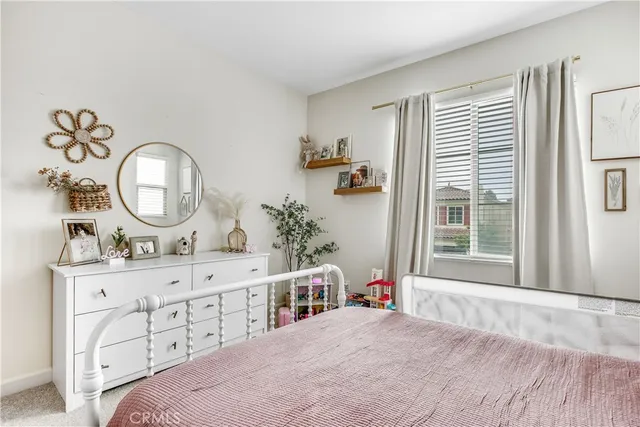 a bedroom with a bed a mirror and a window