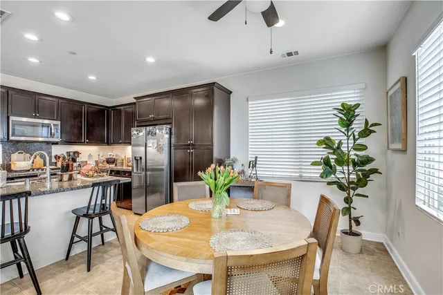 a dining room with stainless steel appliances kitchen island furniture and chandelier