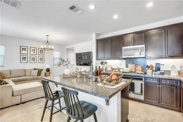 a kitchen with a stove a sink a dining table and chairs
