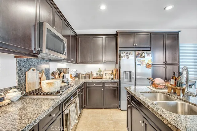 a kitchen with kitchen island granite countertop a sink stainless steel appliances and cabinets