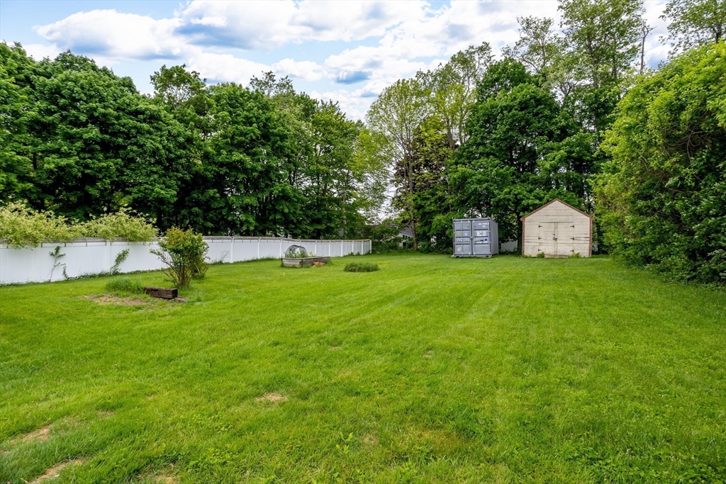 54 Charles Street Gardner, MA 01440 - Photo 36 of 40 a view of a white house with a small yard and large tree