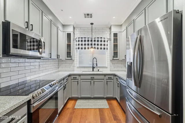 a kitchen with stainless steel appliances granite countertop a sink stove and refrigerator