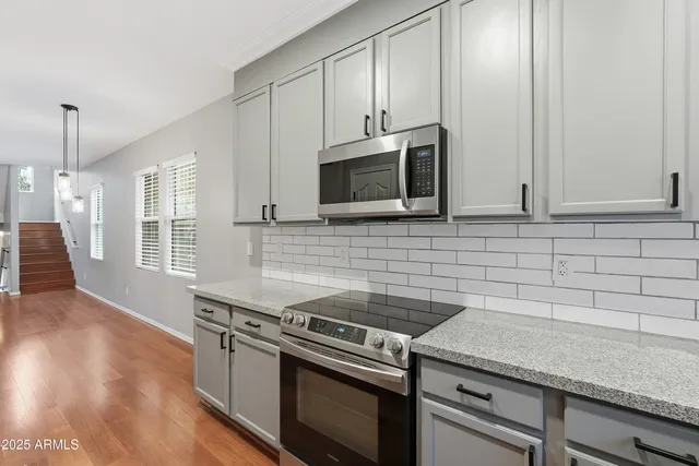a kitchen with granite countertop cabinets stainless steel appliances and wooden floor