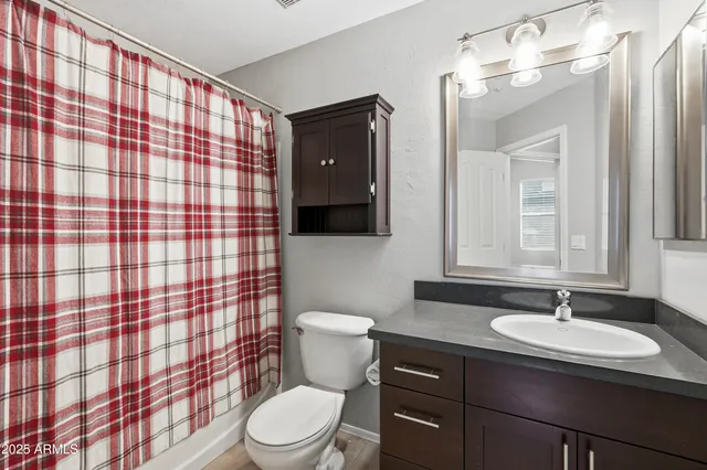 a bathroom with a sink vanity mirror and toilet