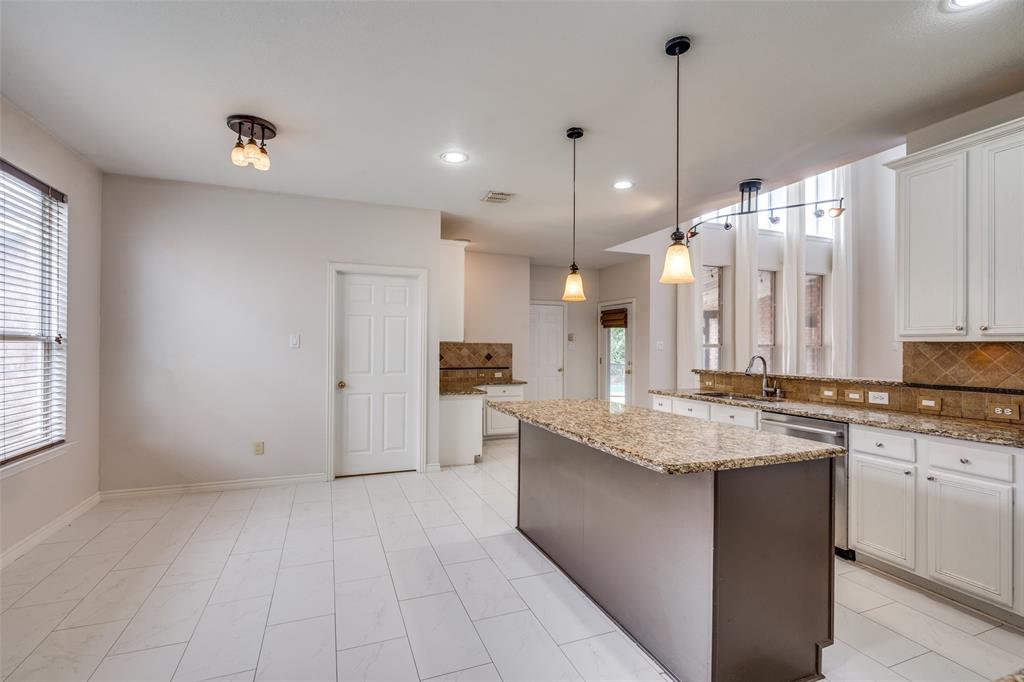 3421 Neiman Road Plano, TX 75025 - Photo 15 of 40 Kitchen featuring stainless steel dishwasher, tasteful backsplash, a kitchen island, white cabinetry, and hanging light fixtures