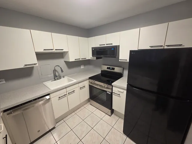 a kitchen with stainless steel appliances a refrigerator sink and microwave