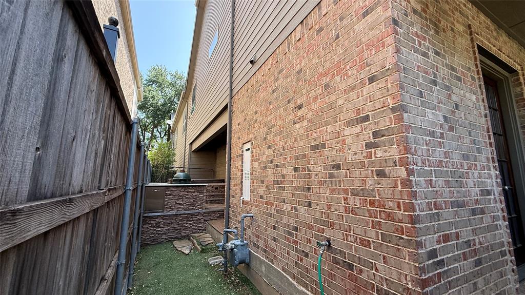 4516 Gilbert Avenue Dallas, TX 75219 - Photo 28 of 28 Brick and siding exterior featuring an outdoor built-in grill station with stone veneer base and integrated cabinetry