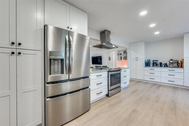 a kitchen with stainless steel appliances a refrigerator sink and cabinets