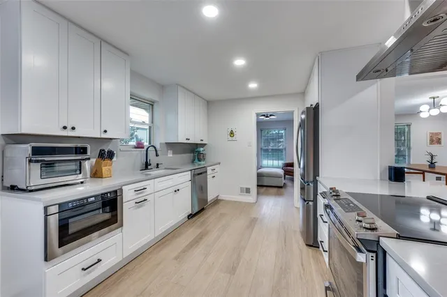 a large kitchen with stainless steel appliances granite countertop a stove and a sink