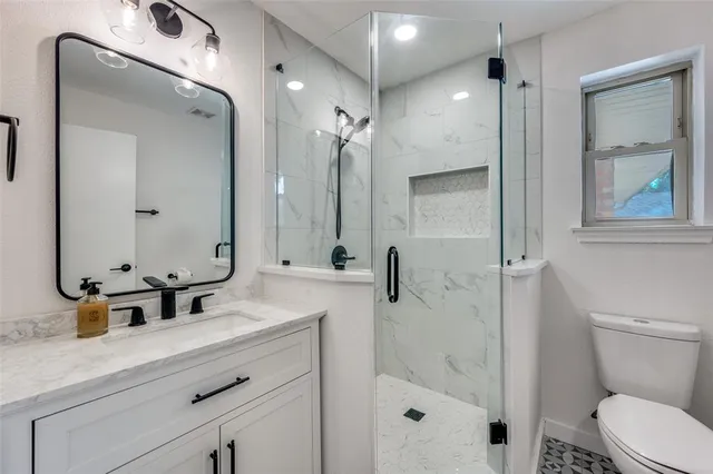 a bathroom with a double vanity sink mirror and toilet