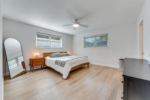 a spacious bedroom with a bed wooden floor and a desk