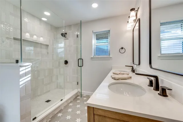 a bathroom with a sink a shower and a mirror