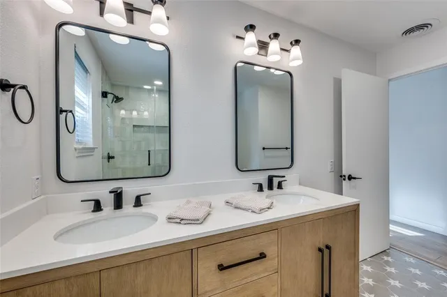 a bathroom with double vanity sinks and a mirror