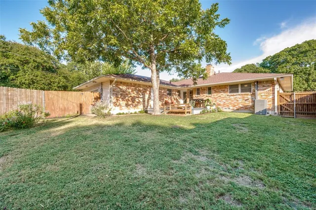 a view of a house with backyard and sitting area