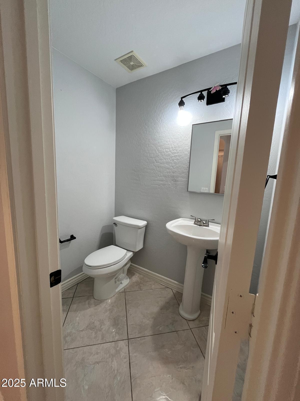 18835 North 16th Place Phoenix, AZ 85024 - Photo 9 of 18 a bathroom with a toilet a sink and mirror