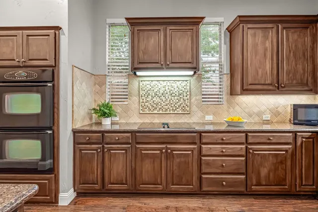 a kitchen with granite countertop a stove a sink and a granite counter tops