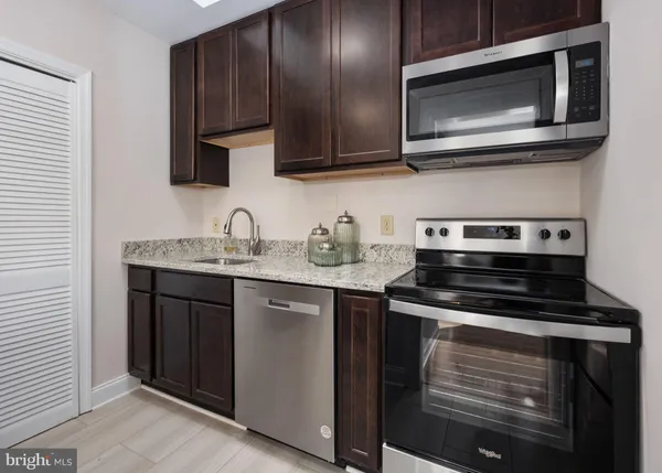a kitchen with stainless steel appliances granite countertop a stove and a microwave