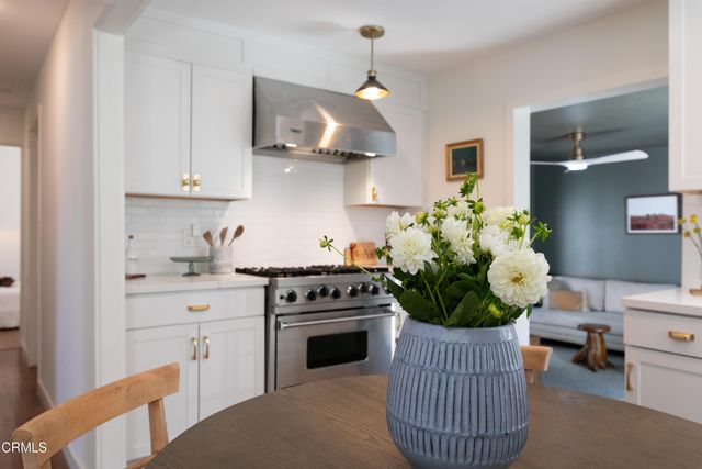 a kitchen with stainless steel appliances granite countertop a stove a white cabinets and a granite counter tops