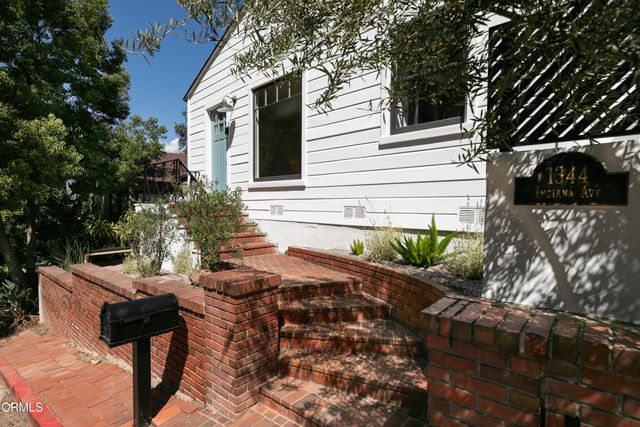 a view of backyard with outdoor seating and plants